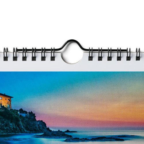 Paper wall calendar with spiral binding and hanging device.